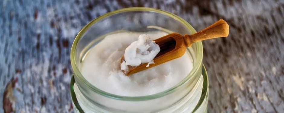 Coconut oil in glass jar with scoop