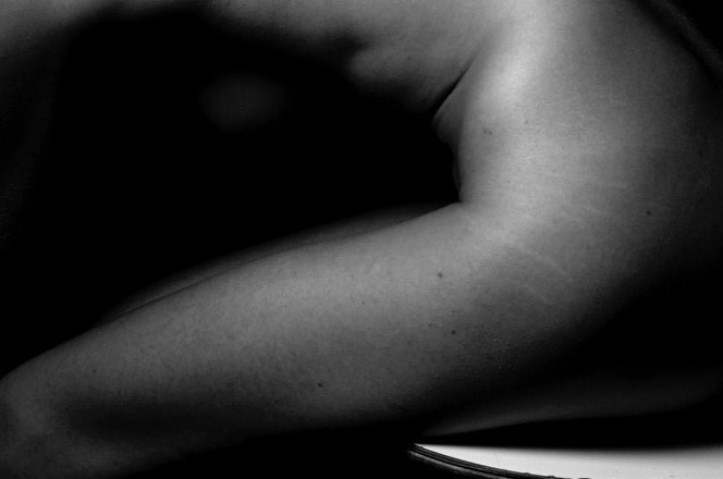 Black and white photo of human body from the side