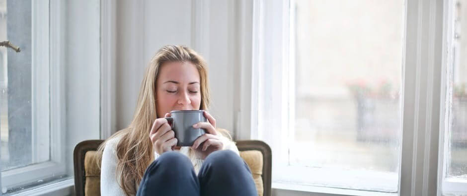 Woman sitting inside sipping tea
